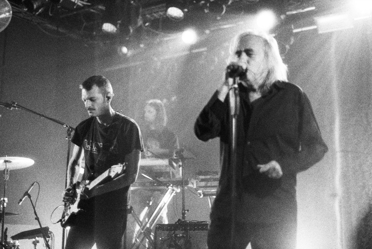 A singer and guitarist on stage, in black and white